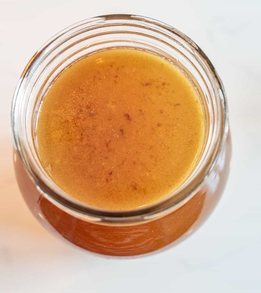 A top view of a glass jar filled with chicken broth. 