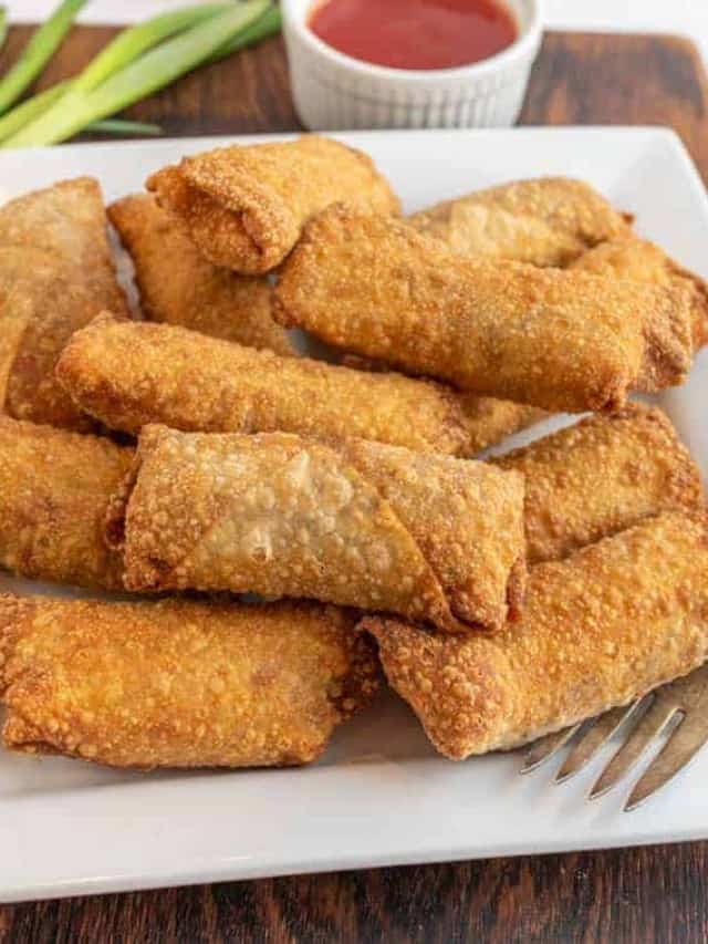close up of a plate of egg rolls.