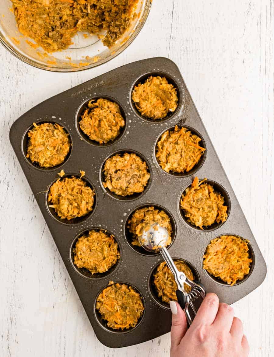 muffin batter being scooped into muffin tins