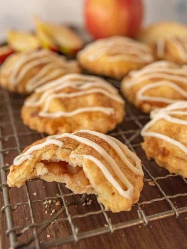 close up of an apple hand pie with a bite taken out of it on a cooling rack