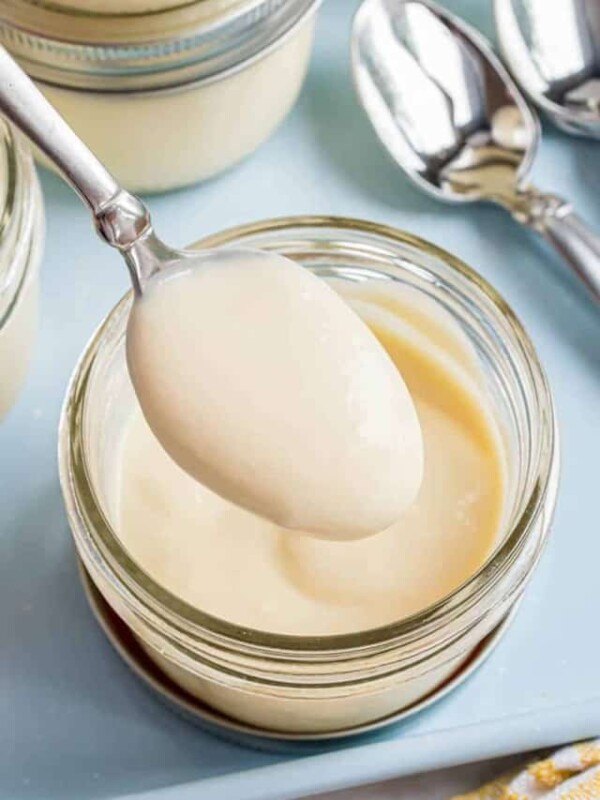 spoonful of vanilla pudding above jar of pudding