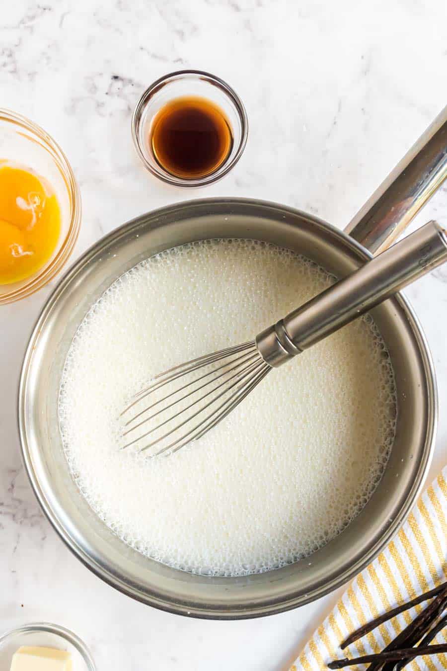 top view of pan of vanilla pudding with a whisk