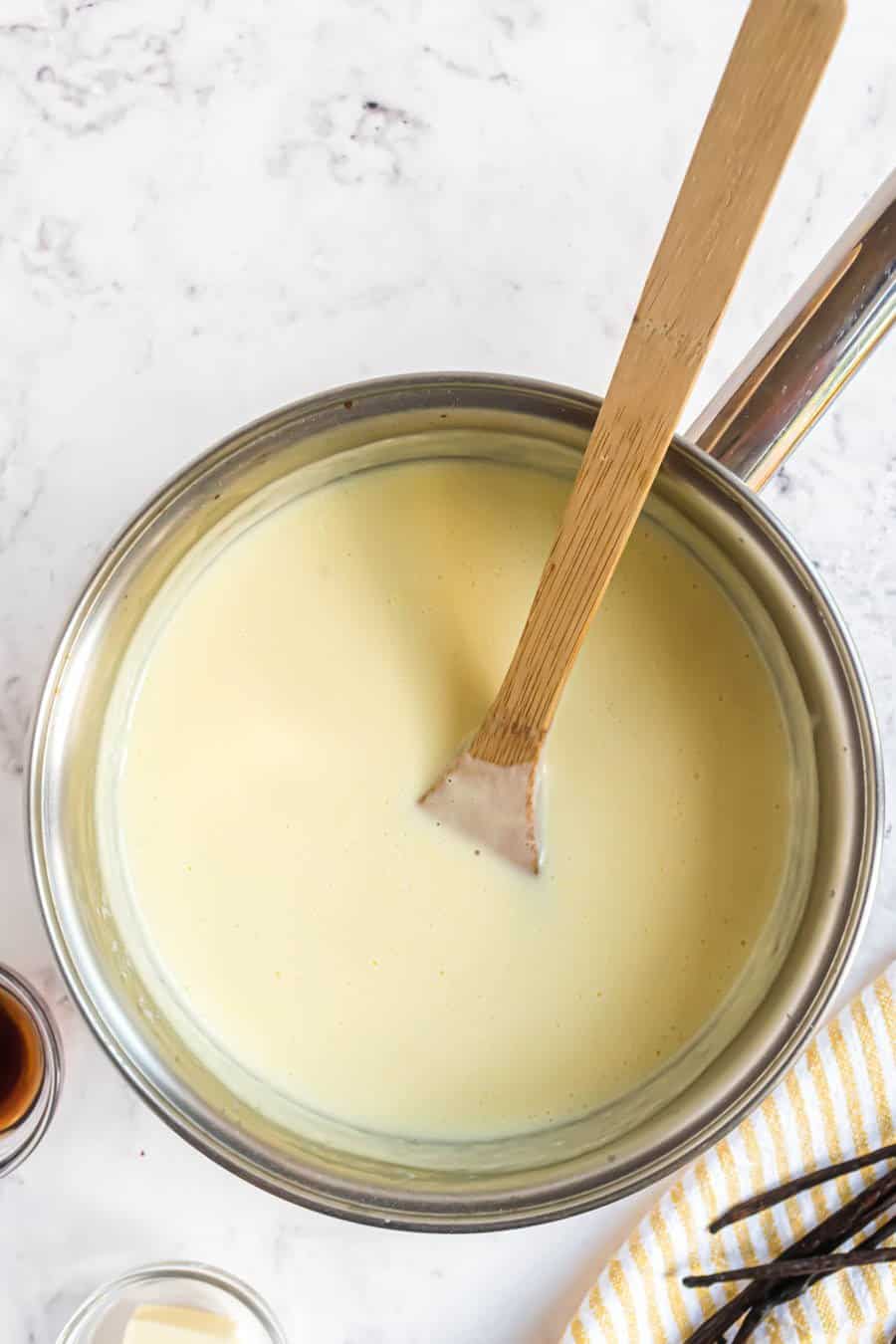 top view of vanilla pudding in pan with wooden spoon