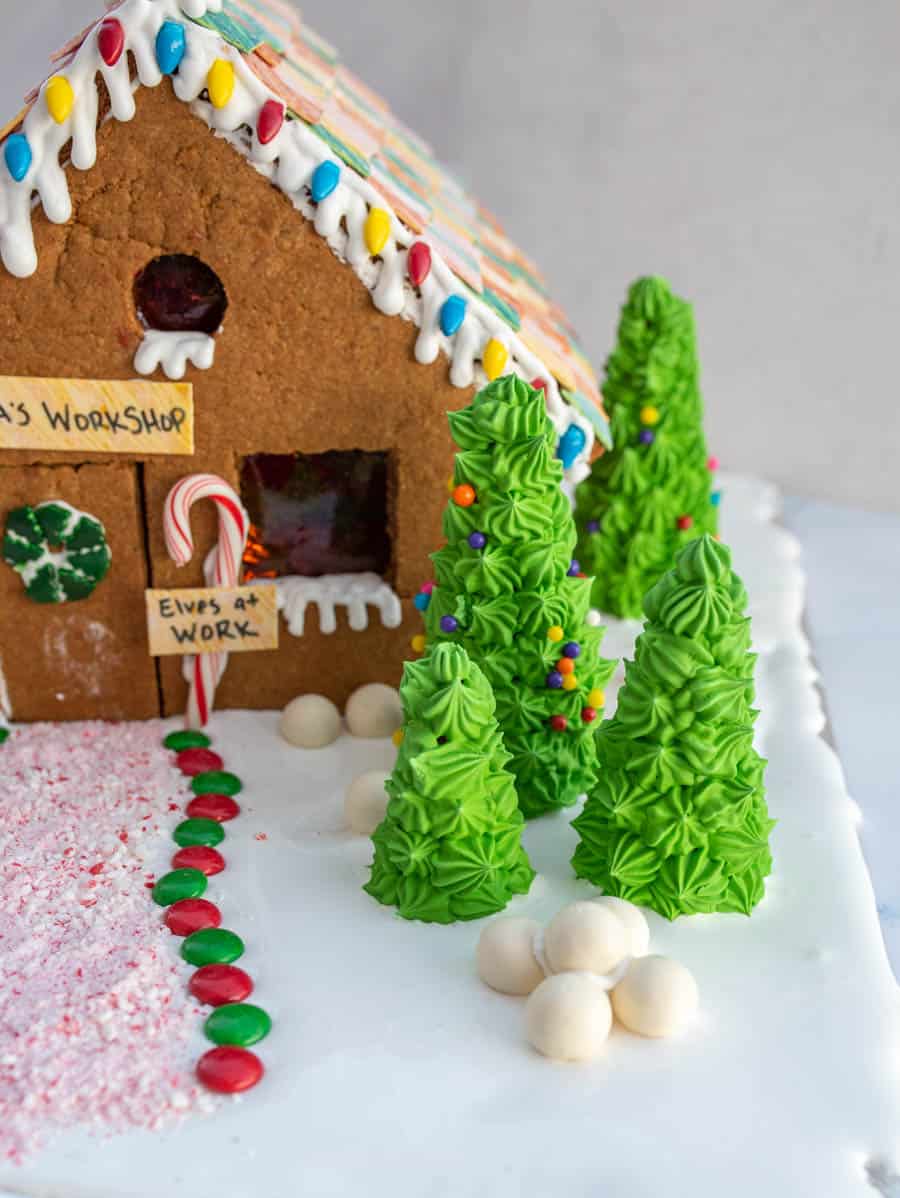 traditional gingerbread house beautifully decorated with a sign that says "santa's workshop"