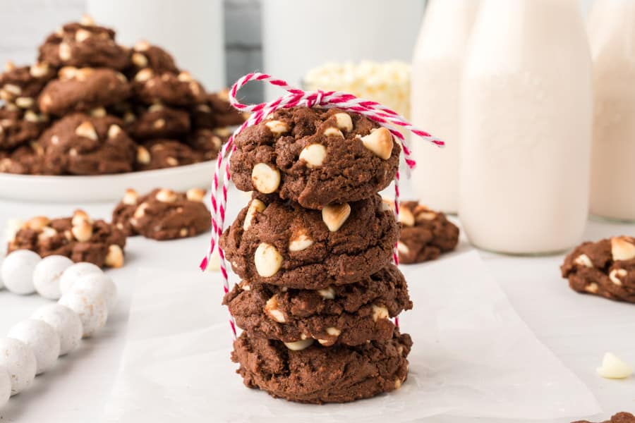 brown chocolate cookies with white chocolate chips in a stack of four and a pink and white string around them.