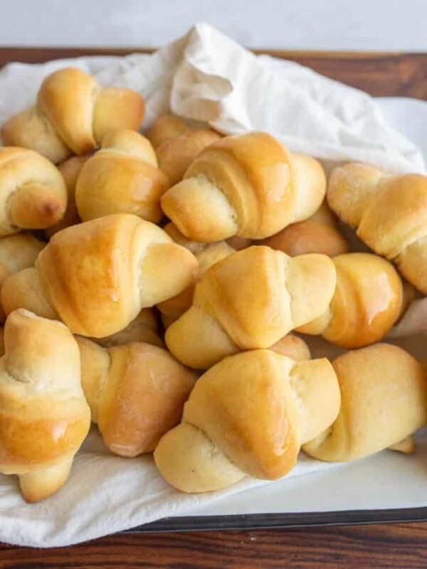 small shiny buttered rolls in a rolled up croissant shape