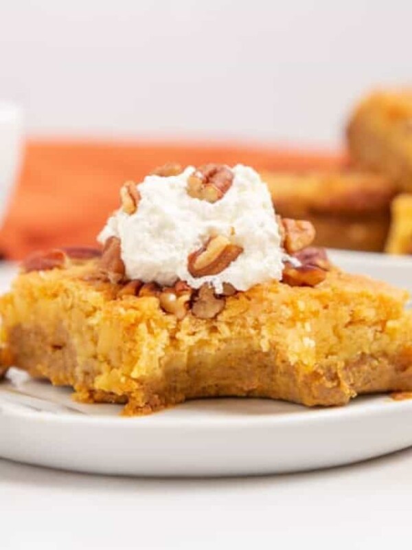 one square slice of a pumpkin dump cake with pecans on top