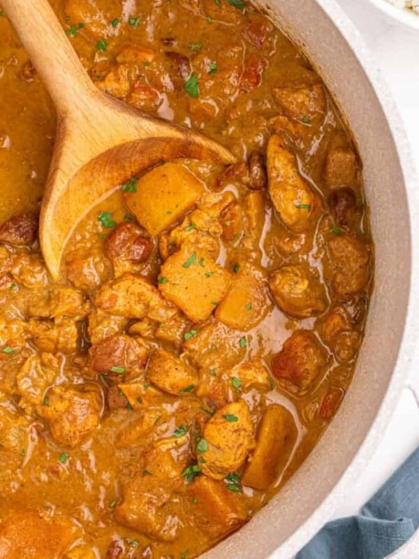 close up in the bowl of pumpkin curry being stirred with a spoon