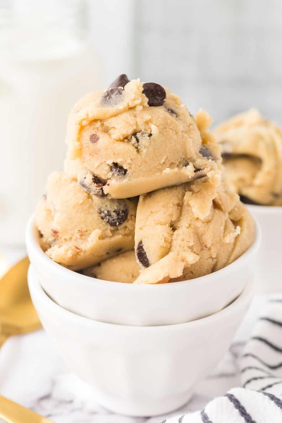 white bowls of round scoops of edible cookie dough.