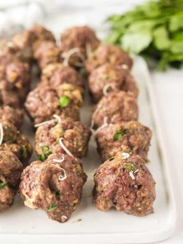 close up of baked meatballs in rows on a platter