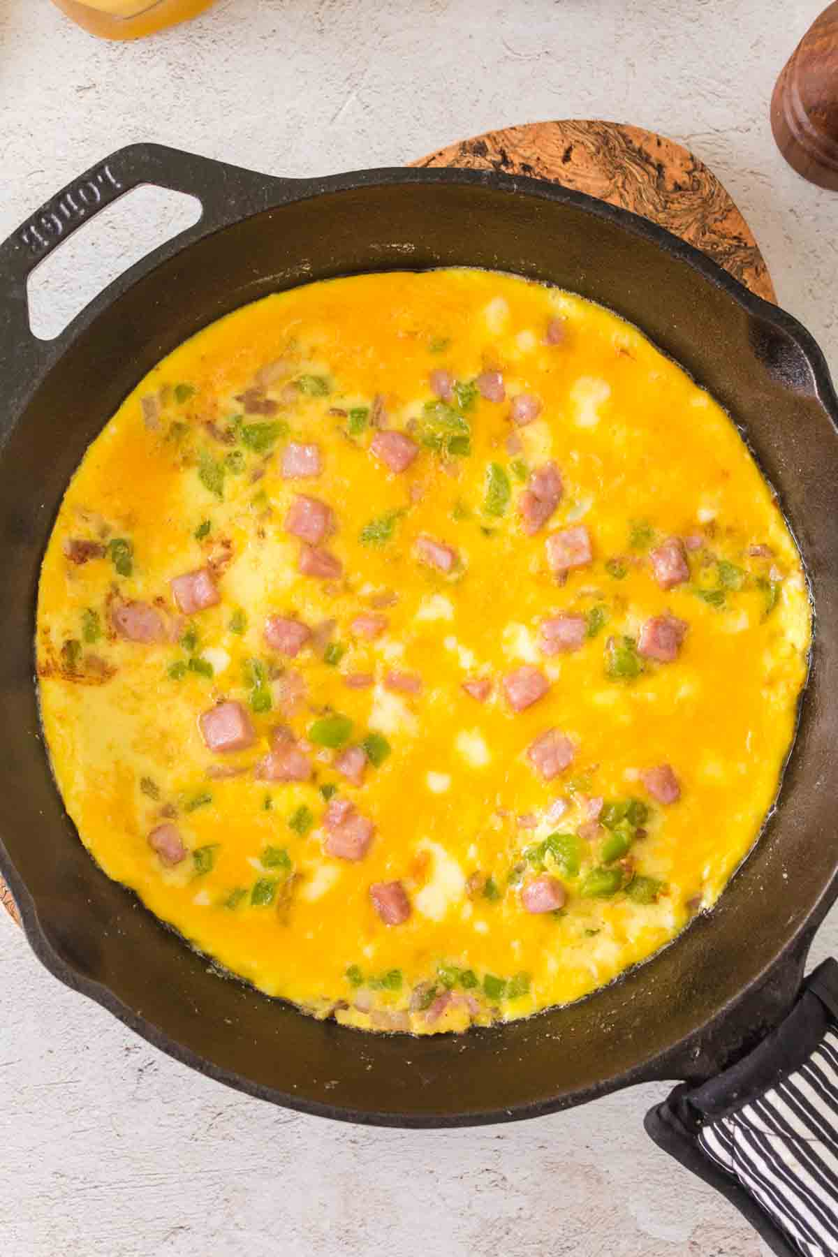 omelet being cooked in the cast iron pan.