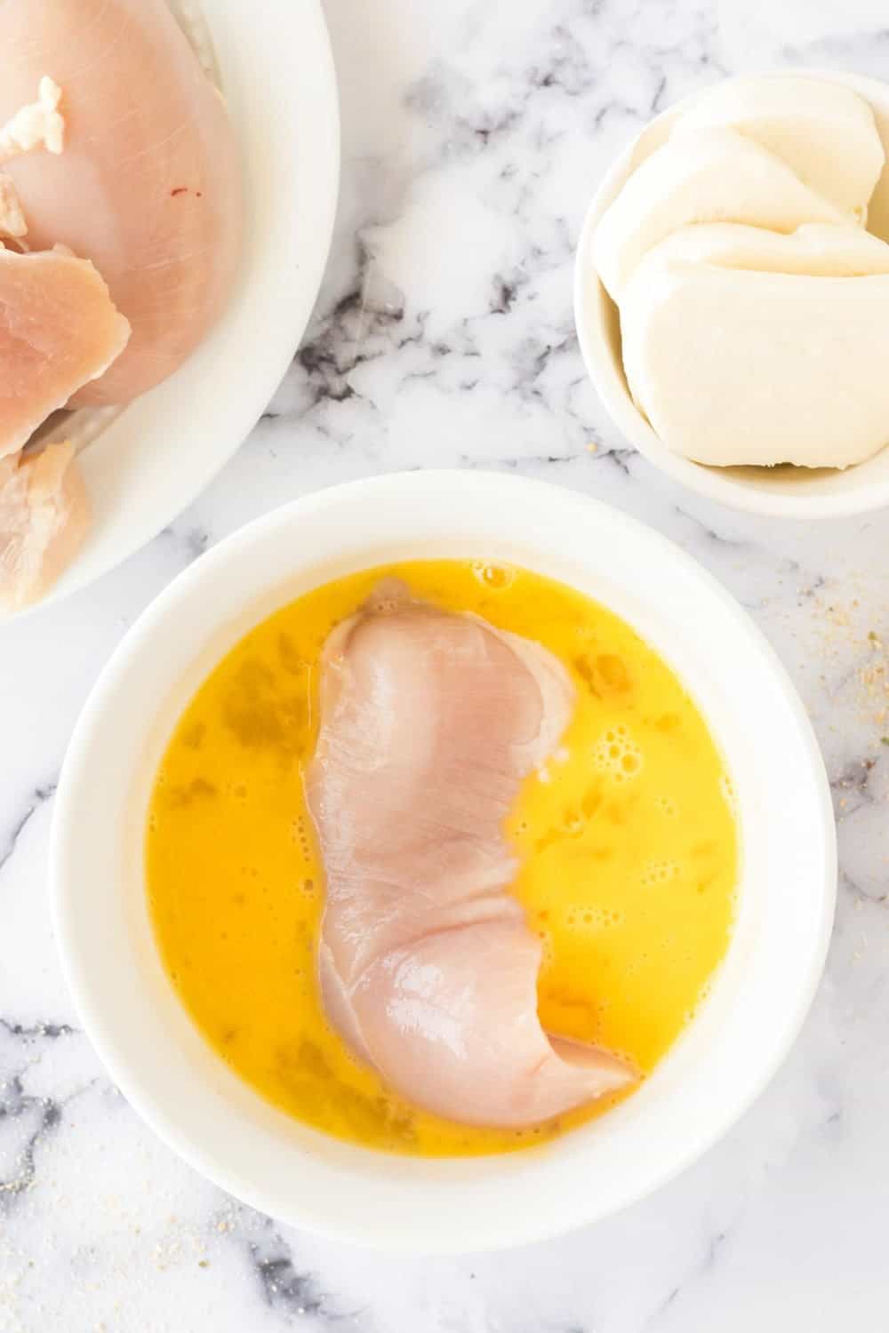 raw chicken being breaded for chicken farm