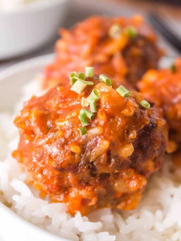 close up of porcupine meatballs with sauce over rice