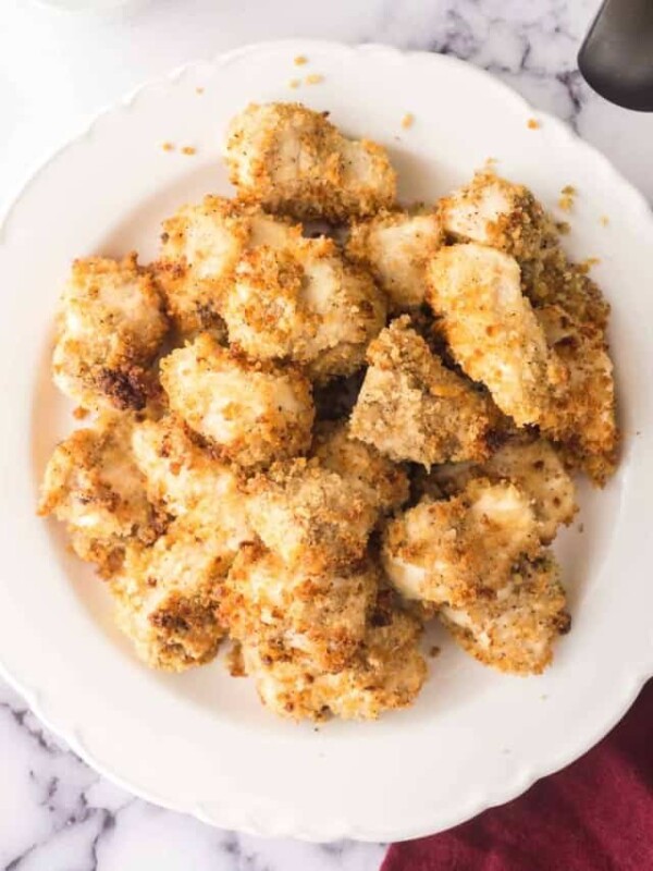 air fryer chicken nuggets on a white plate with ketchup on the side