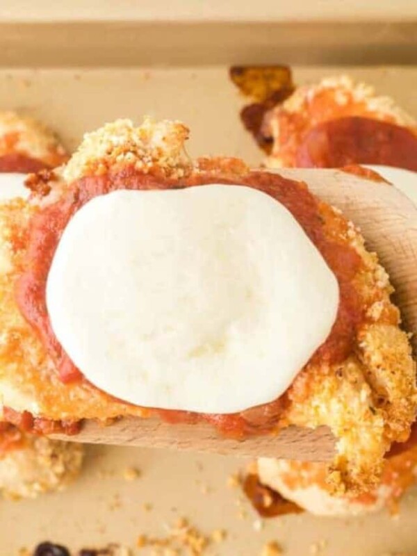 baked chicken parmesan top view on a wooden spatula over the baking dish