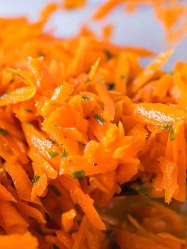 close up shredded carrot salad in a mixing bowl