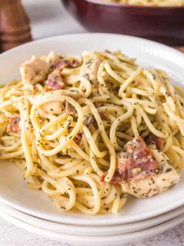 chicken carbonara with bacon and cheese on a white plate