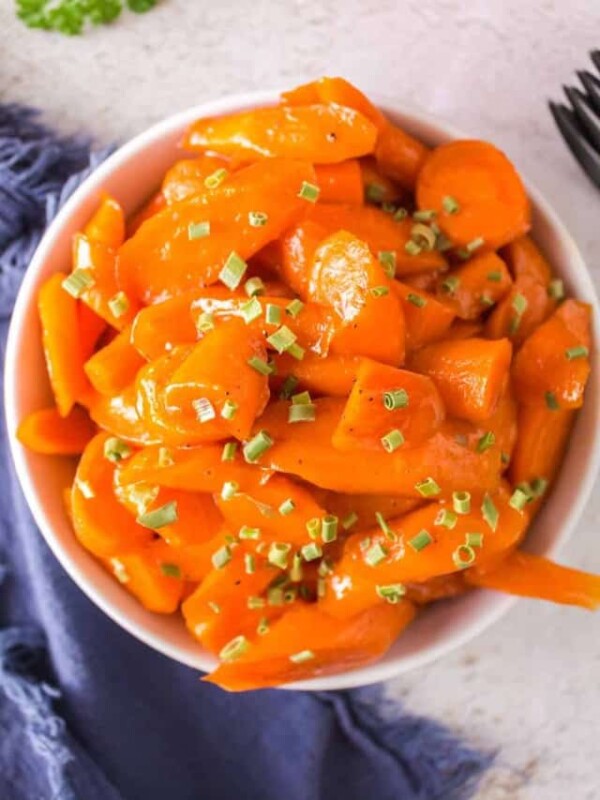 glazed carrots in a white dish with chives on top