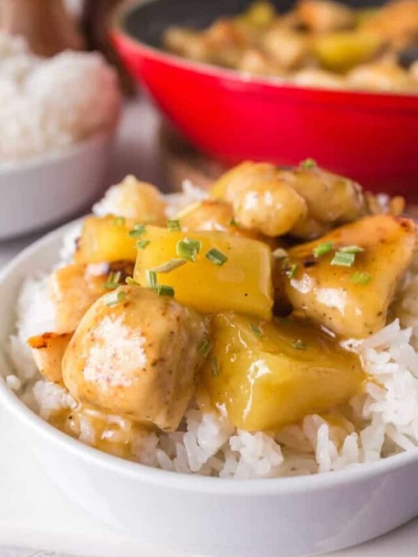 pineapple chicken served on a plate over a bed of rice