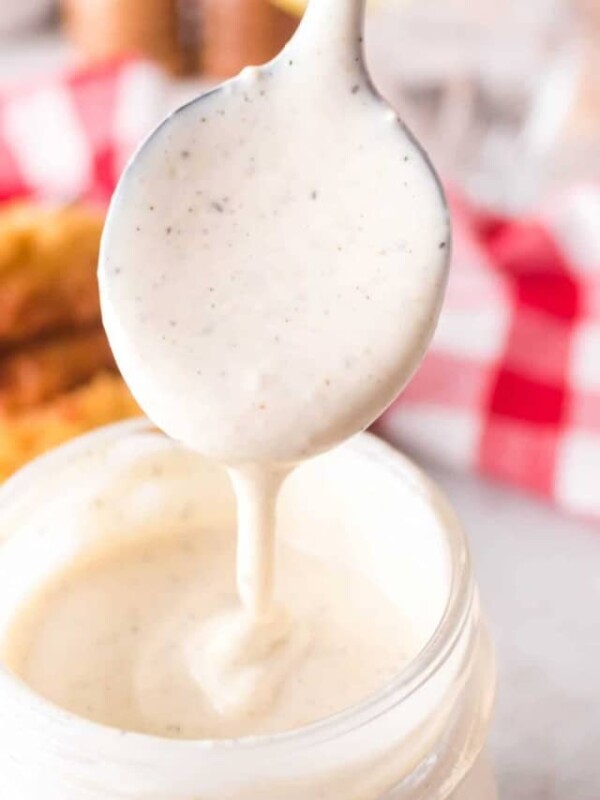 white BBQ sauce in a mason jar with a spoon