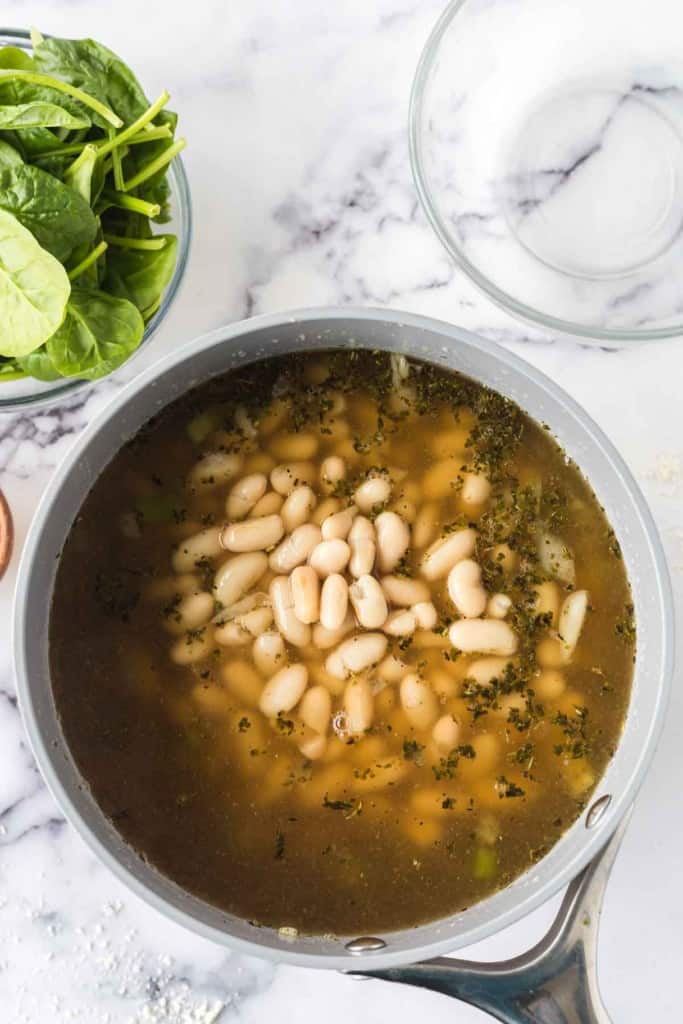 white bean soup in a sauce pan.