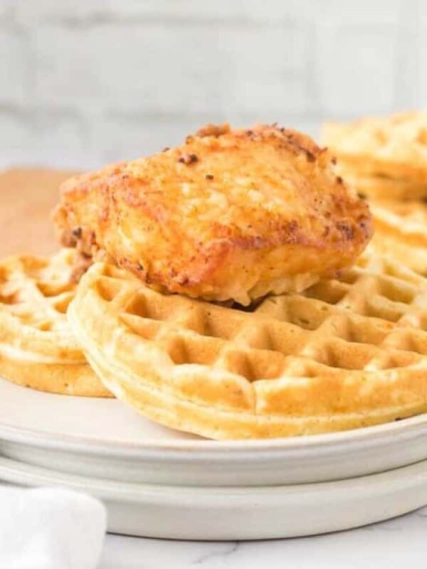 crispy chicken atop homemade waffles and maple syrup