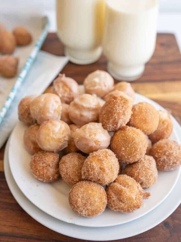 plate stacked with round iced and sugar donut hole bites