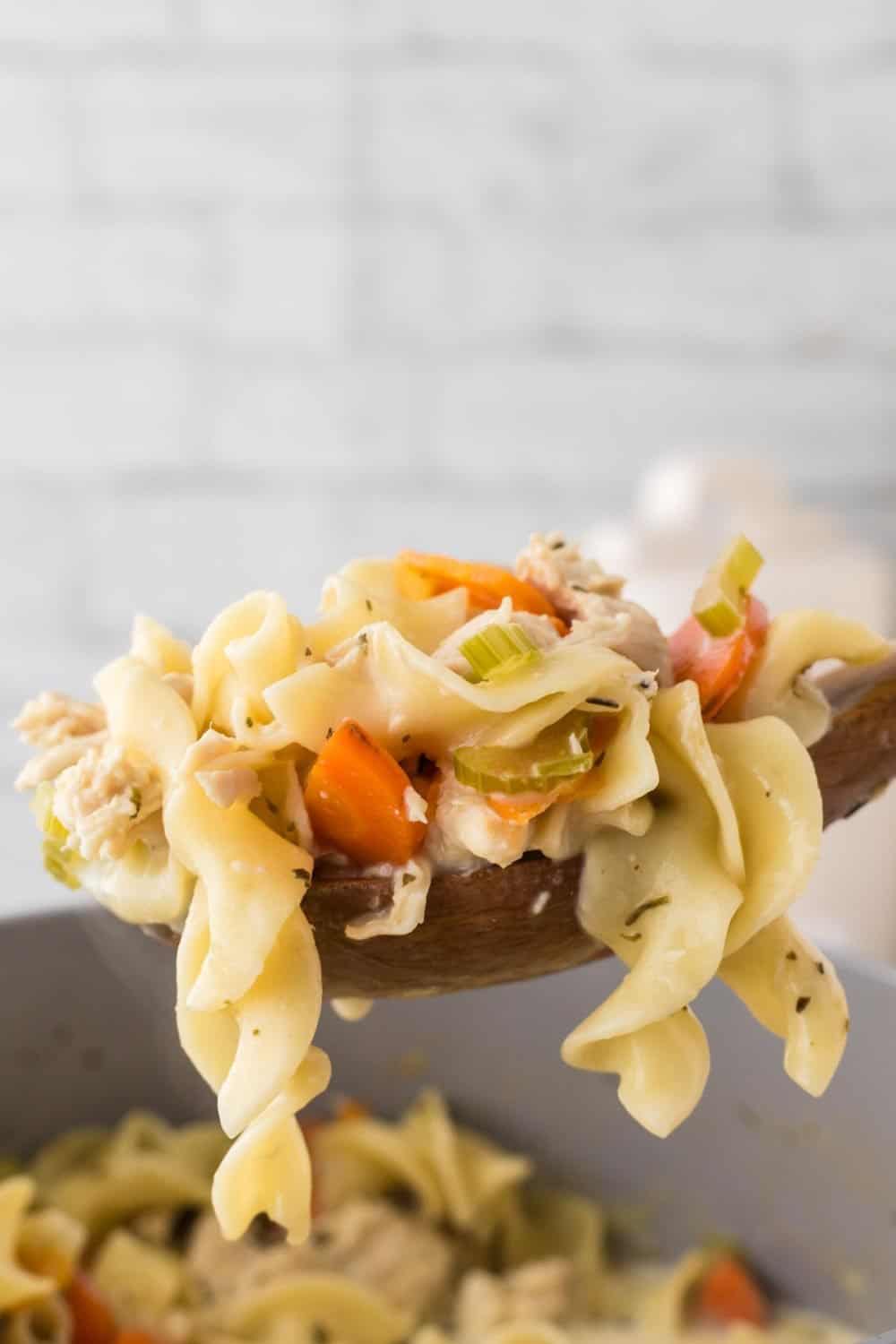 wooden spoon full of creamy chicken noodle soup