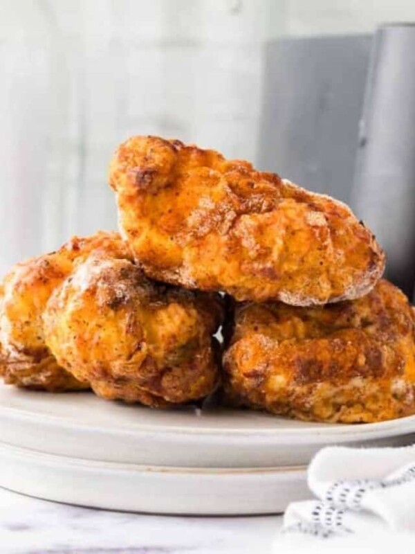 close up of three pieces of air fryer fried chicken stacked on a plate