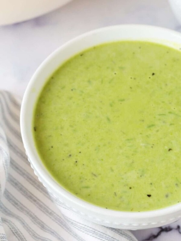 vibrant green pea soup in serving bowls and gold spoons