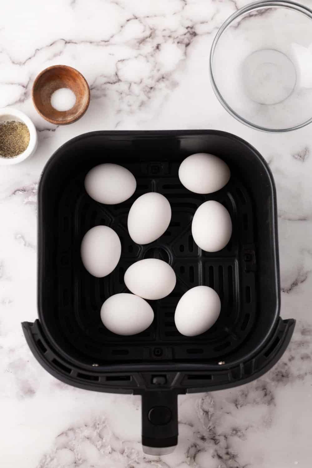 whole eggs in a black deep fryer basket.