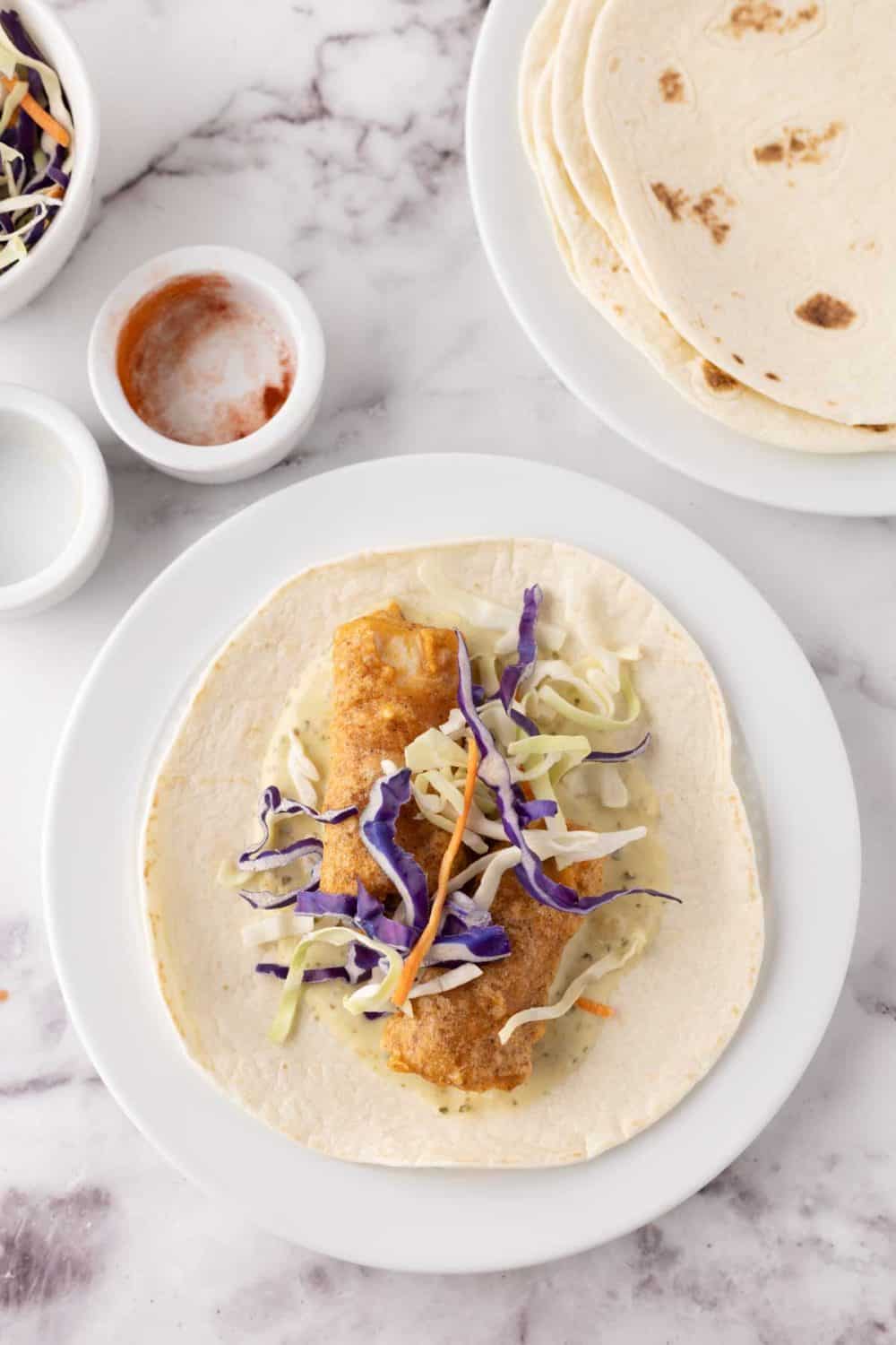 deep fried baja fish taco recipe with cabbage on a flour tortilla.