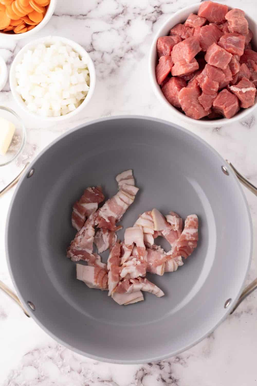 pan with bacon and other raw ingredients forBeef Bourguignon Recipe.