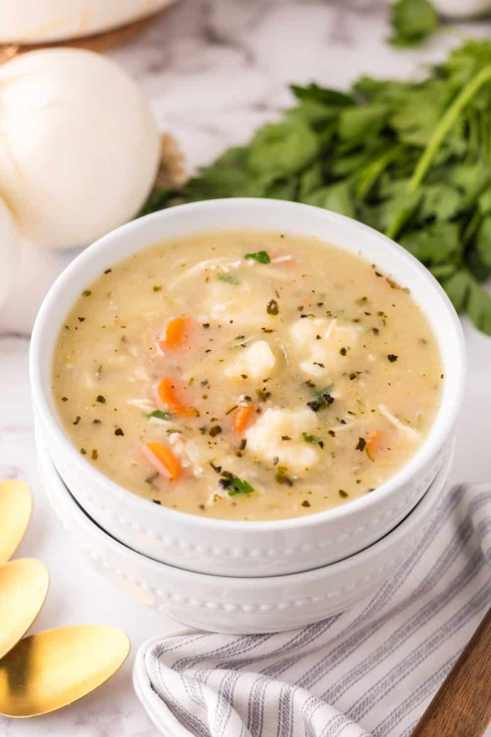 bisquick dumplings recipe in a white bowl with golden spoons.