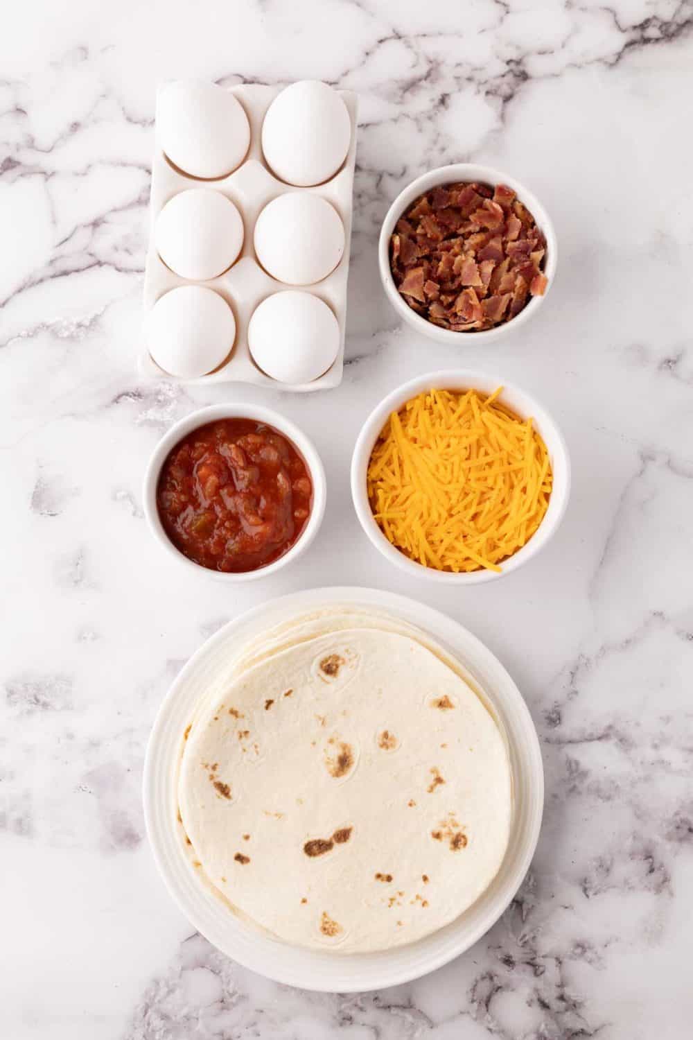 portion bowls each with raw ingredient to make breakfast tacos.