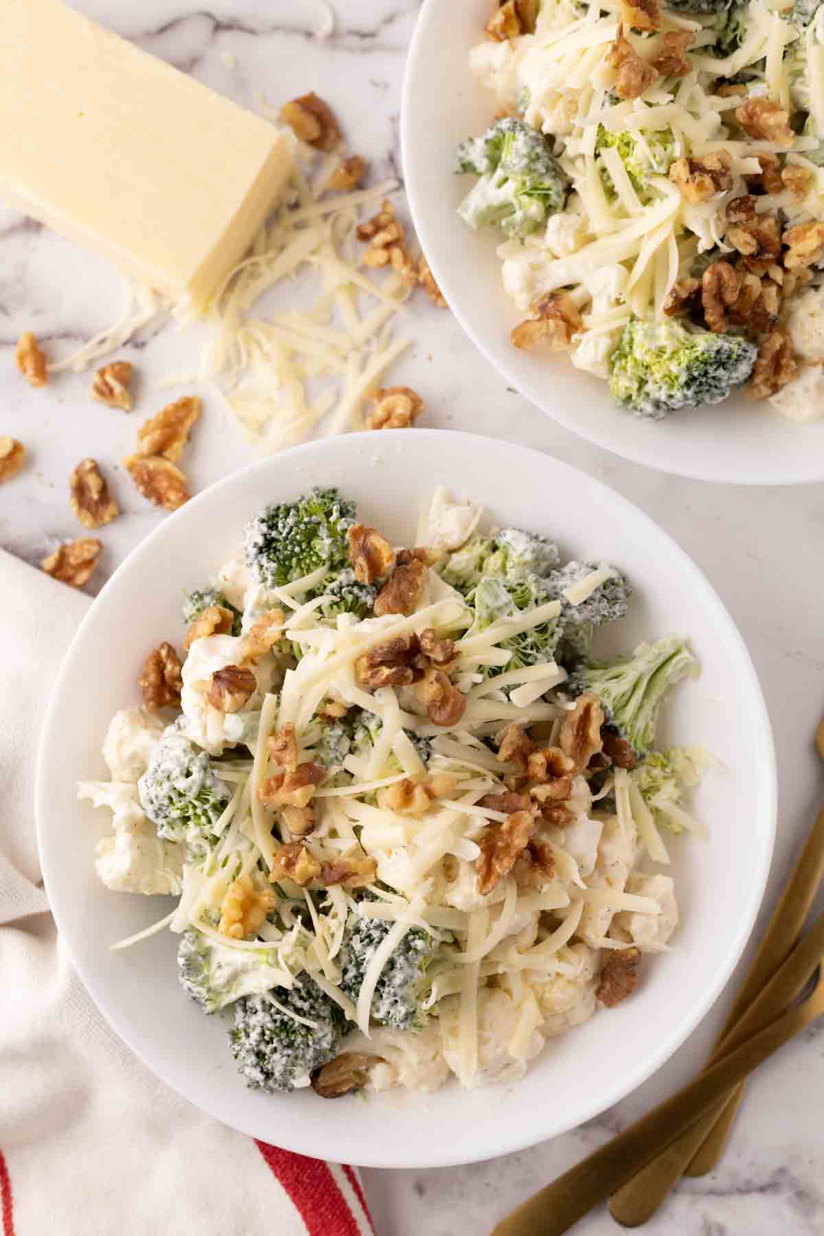 white plate with broccoli and cauliflower salad recipe.