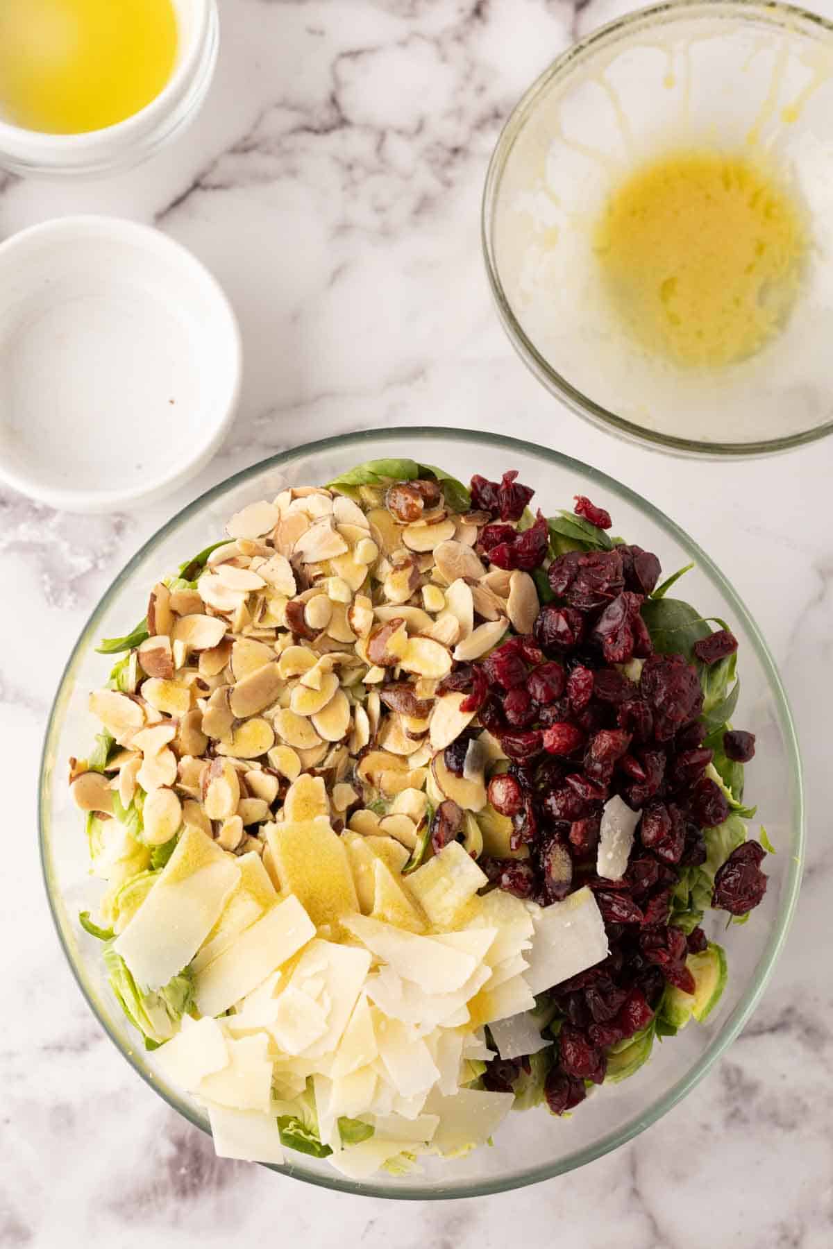 glass mixing bowl with ingredients to make Brussels sprouts salad recipe.