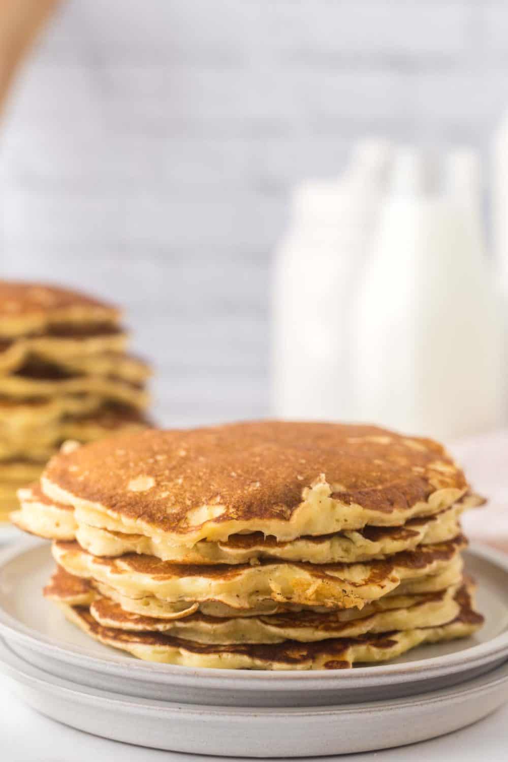 buttermilk pancakes stacked on a round plate.