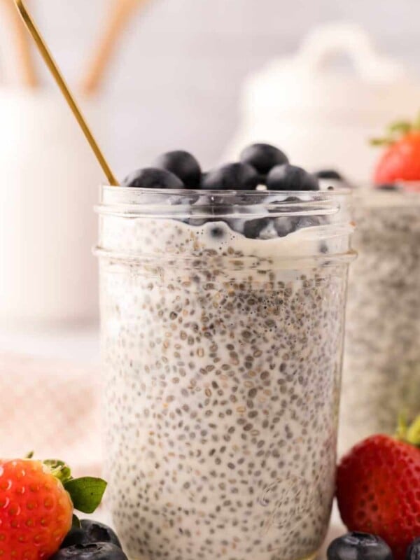 chia seed pudding in small mason jars with strawberries and blueberries.