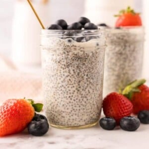 chia seed pudding in small mason jars with strawberries and blueberries.