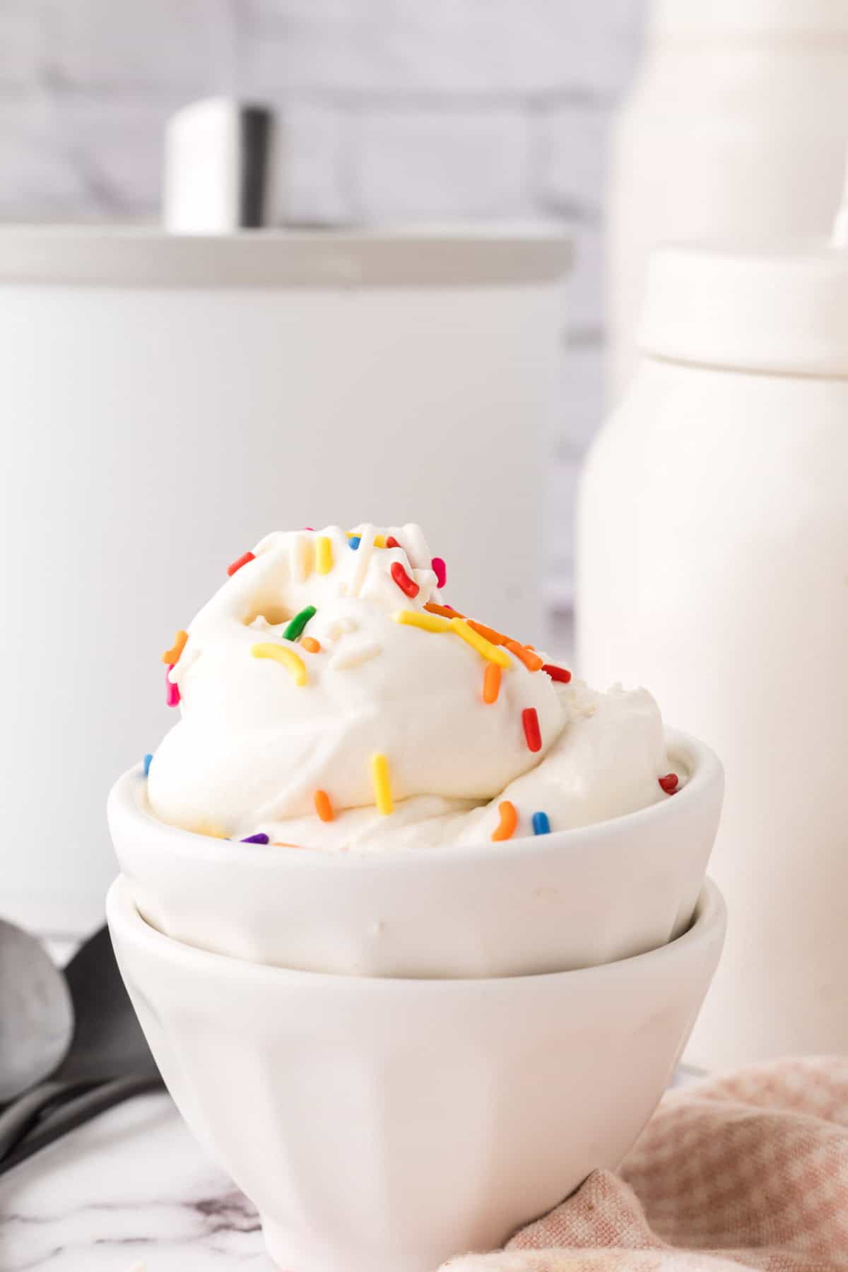 cake batter ice cream in a white dish with rainbow sprinkles.