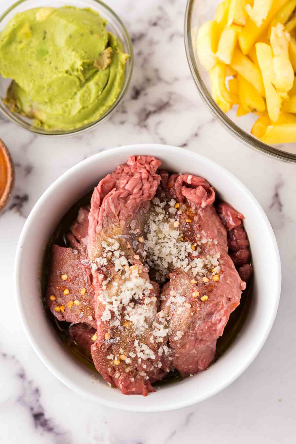 portion bowls each with raw ingredients to make California burritos.