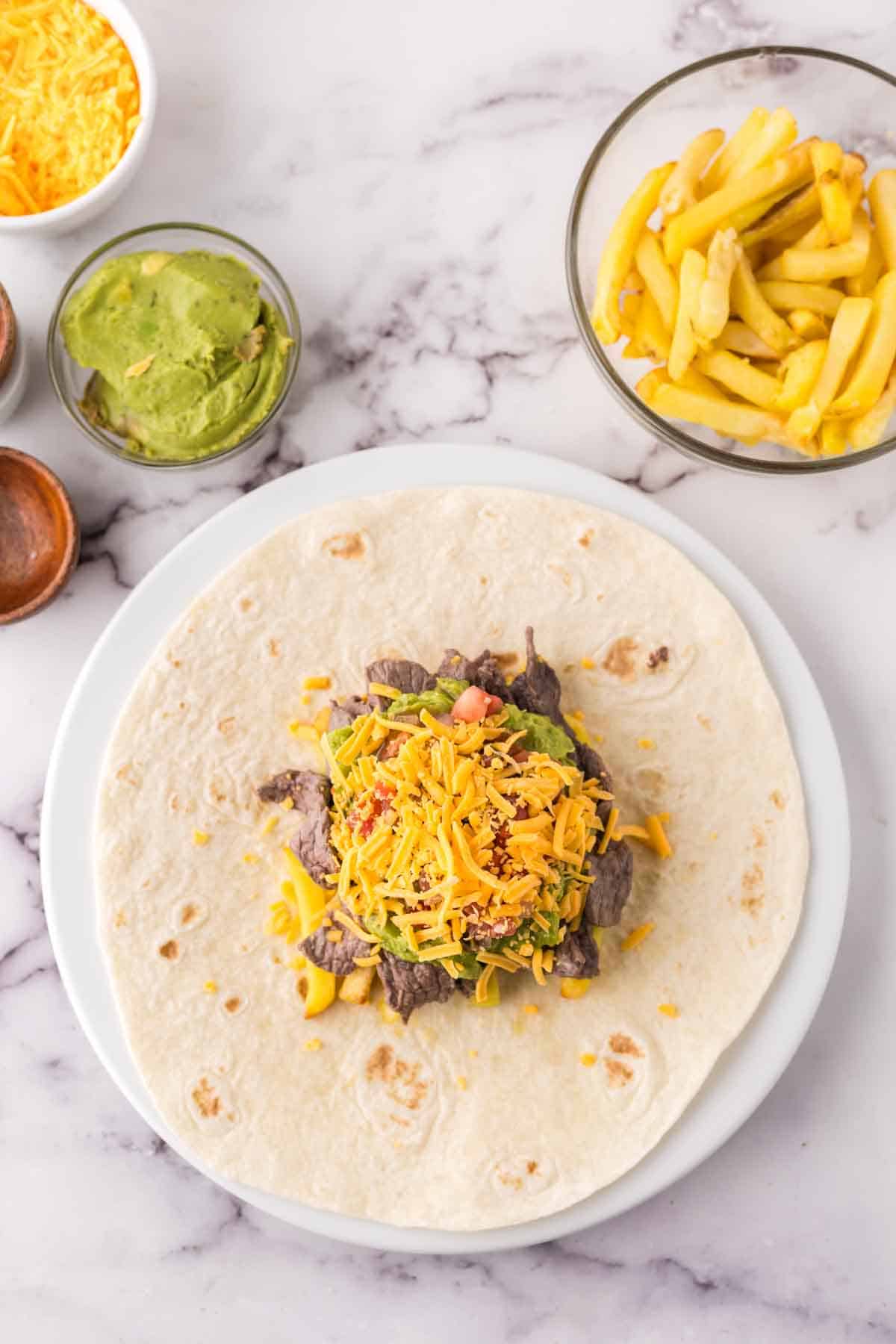 tortilla with ingredients going on top for California burritos.