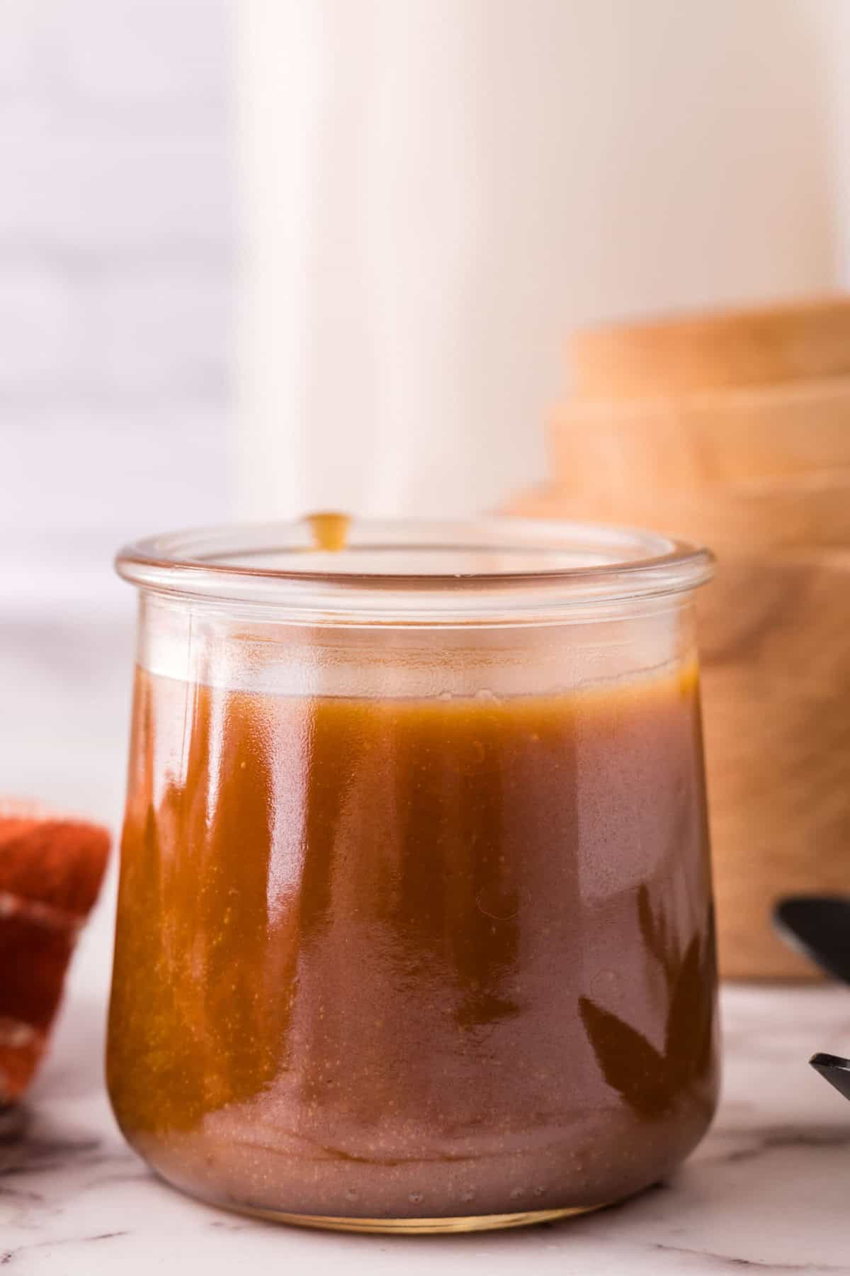 glass jar filled with homemade caramel sauce.