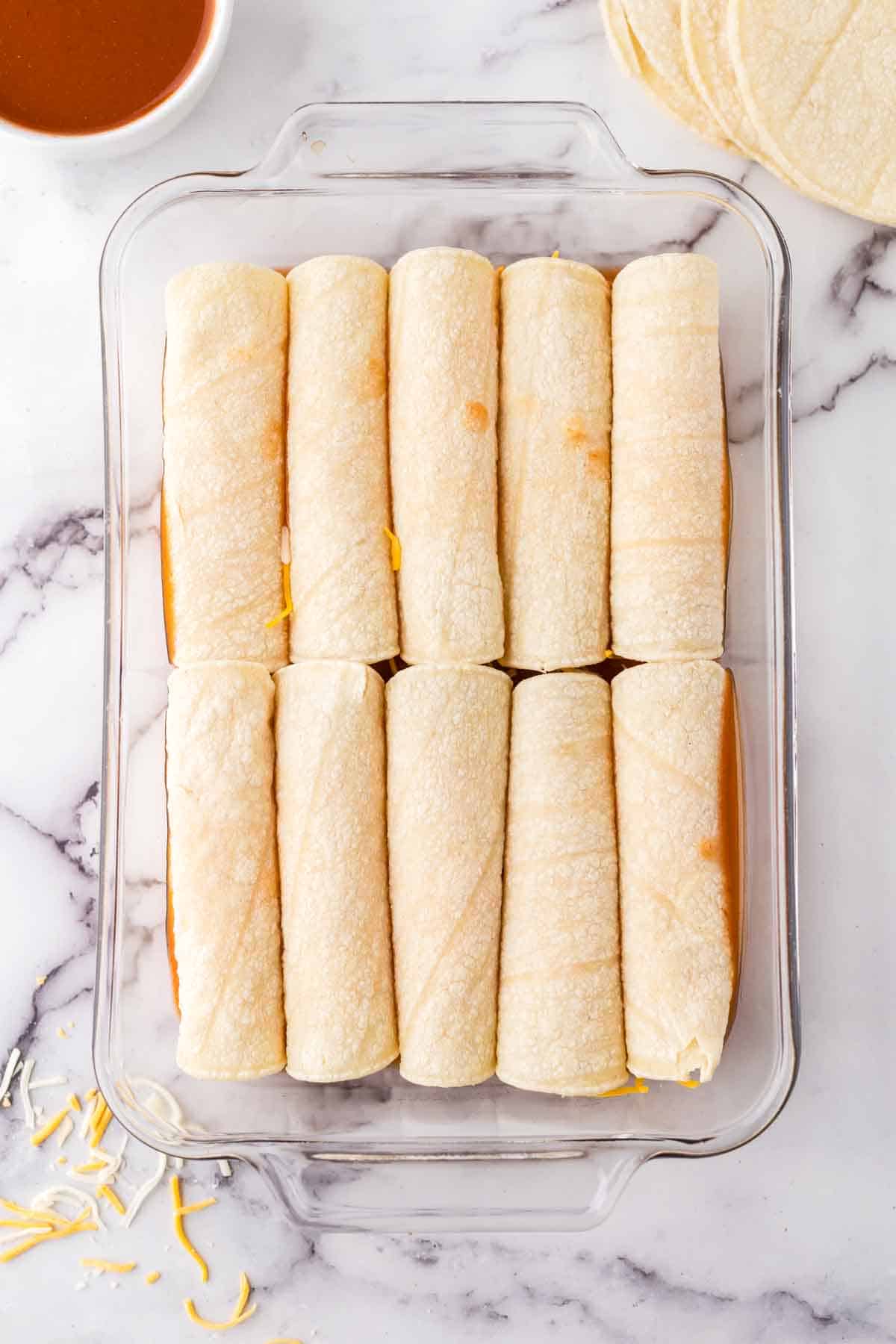 tortilla rounds inside a baking dish ready for enchilada sauce.