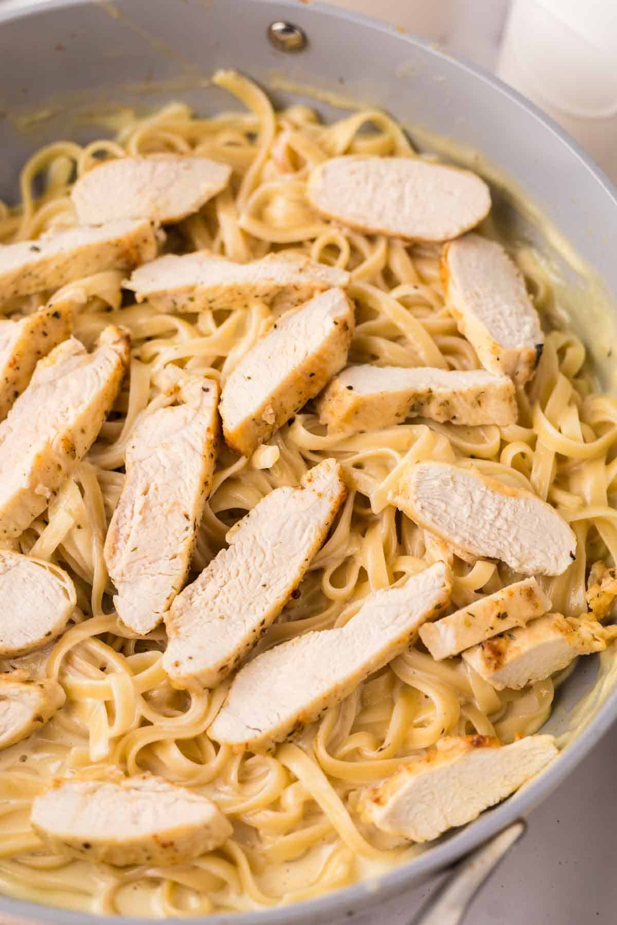 chicken fettuccine alfredo recipe in a sauce pan ready to serve.