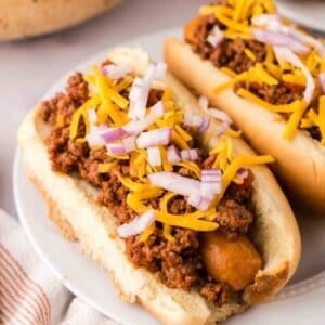 chili dogs recipe over round white plates.