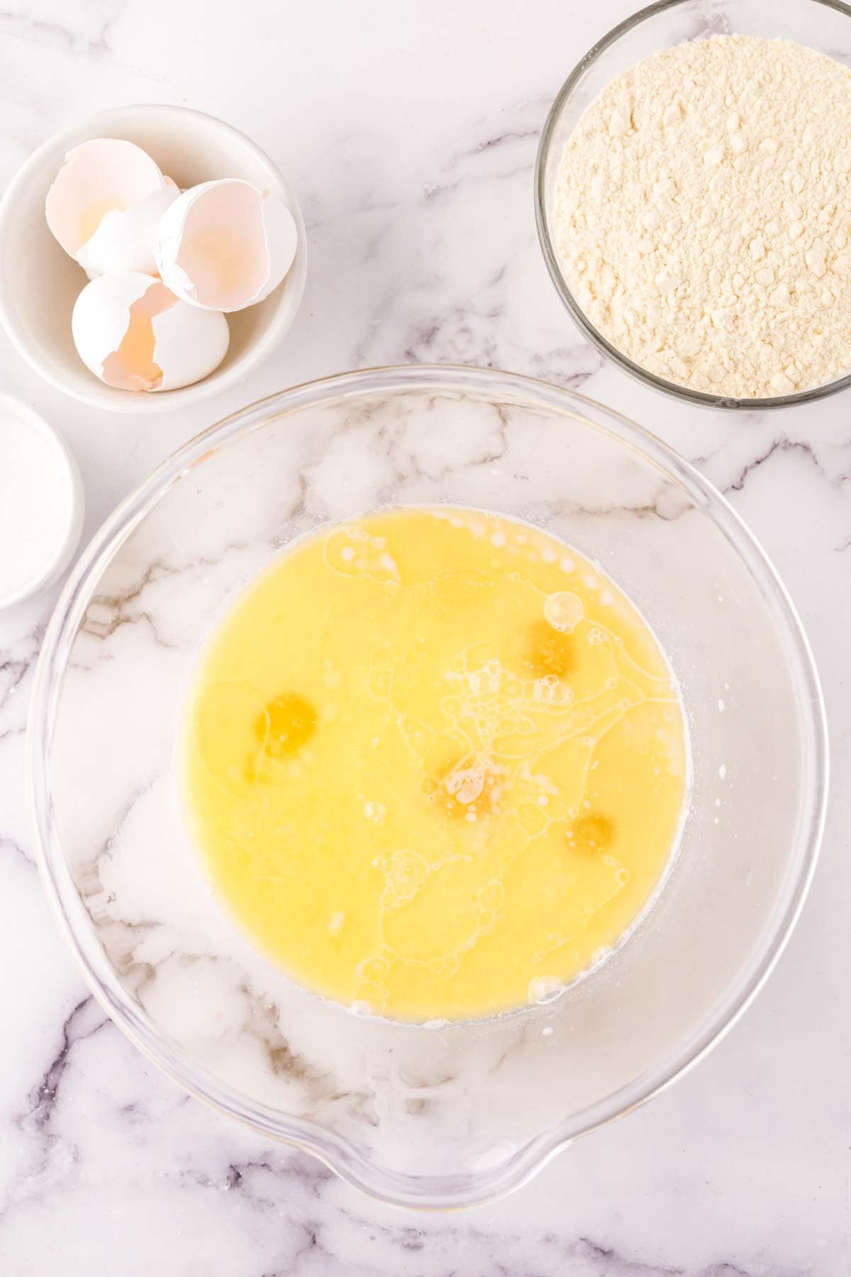 clear mixing bowl in the process of making crepe batter.