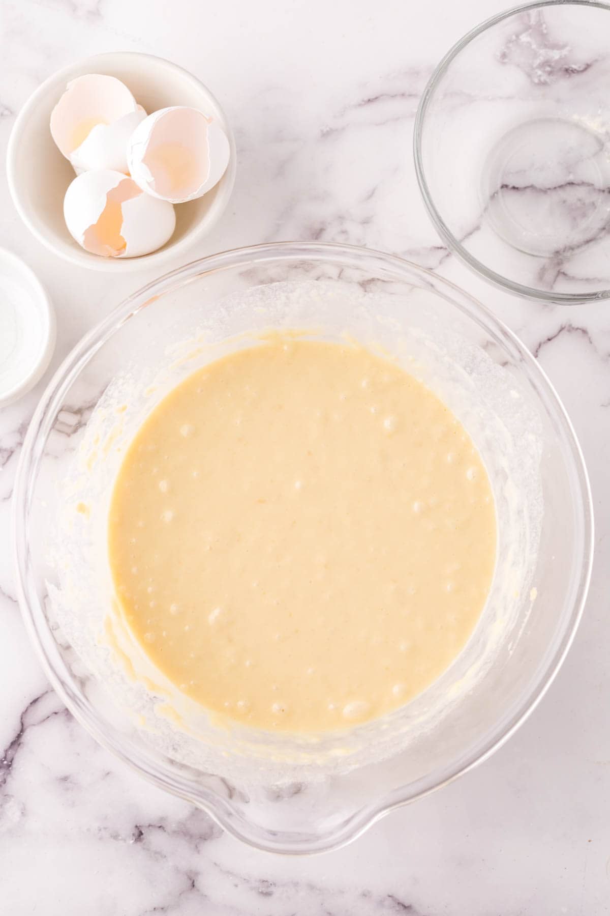 clear mixing bowl in the process of making crepe batter.