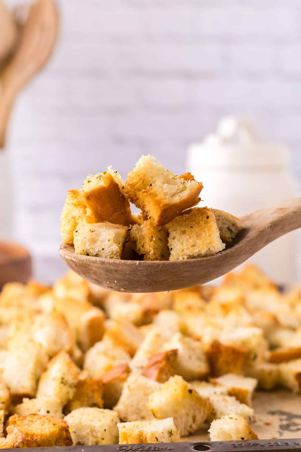 wooden spoon over a bakings sheet with homemade crouton recipe.